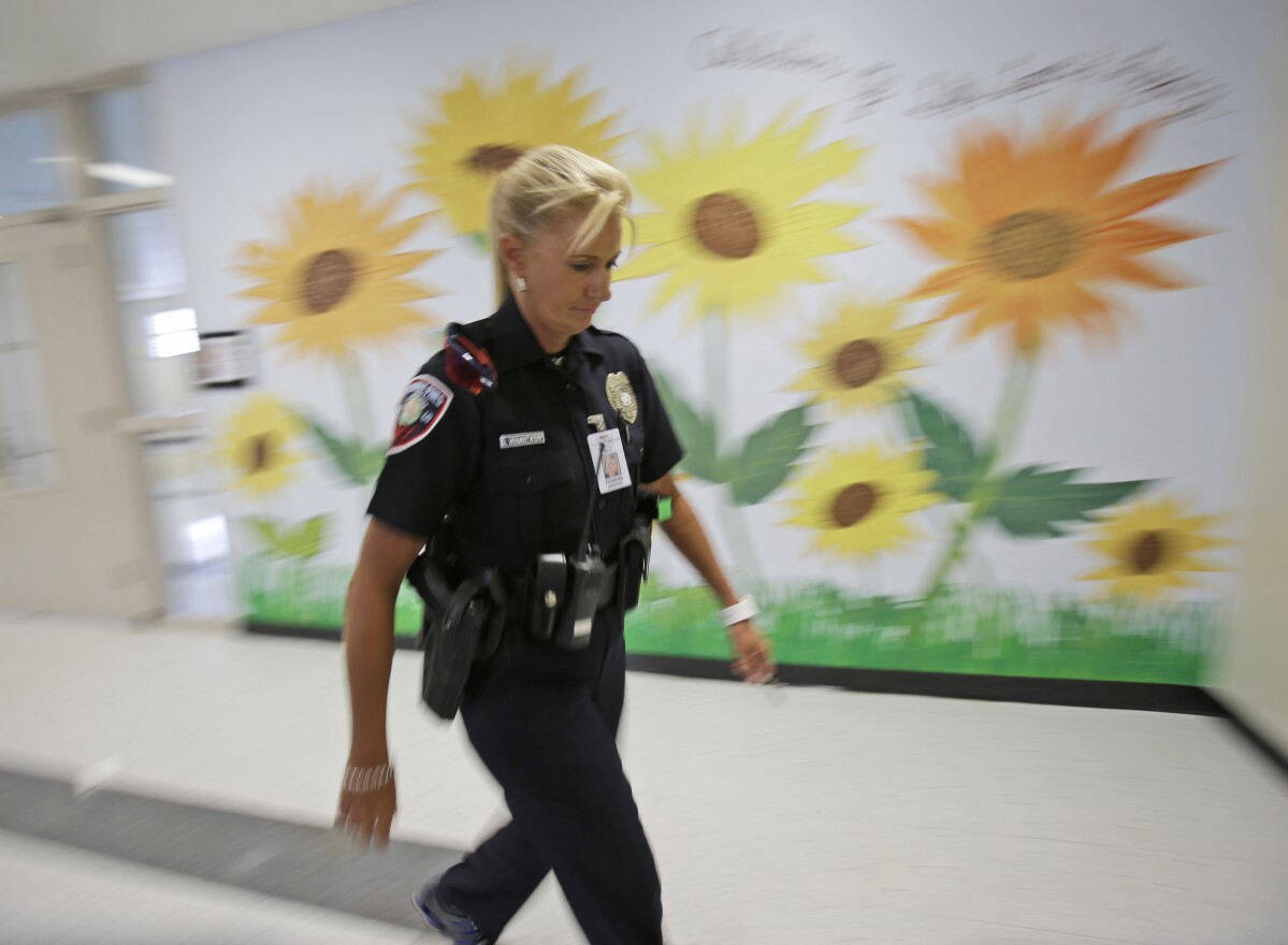 Dara Van Antwerp, the school resource officer at Panther Run Elementary School Pembroke Pines, Fla. walks the hallways of the school where she works on Aug. 22, 2013.